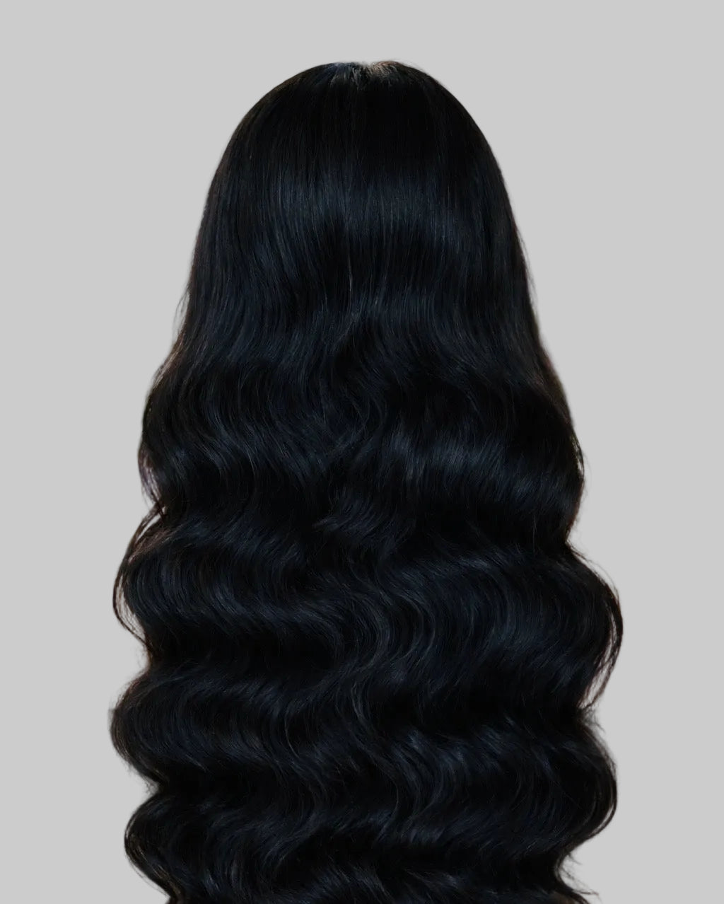 Person with long, wavy black hair in a salon setting