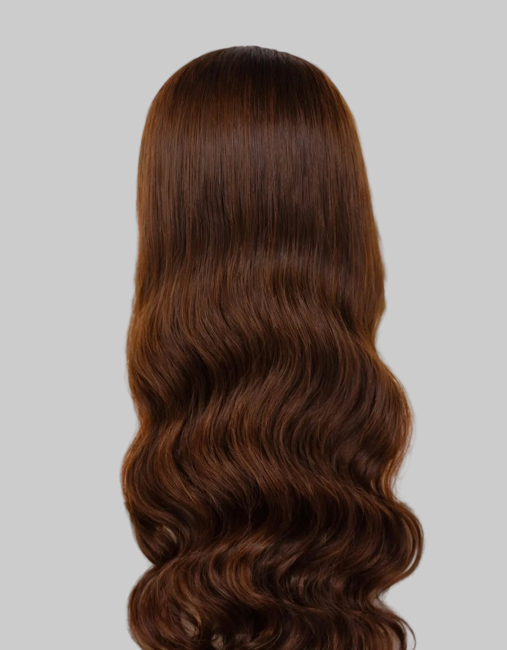 Person with long, wavy brown hair in a salon setting