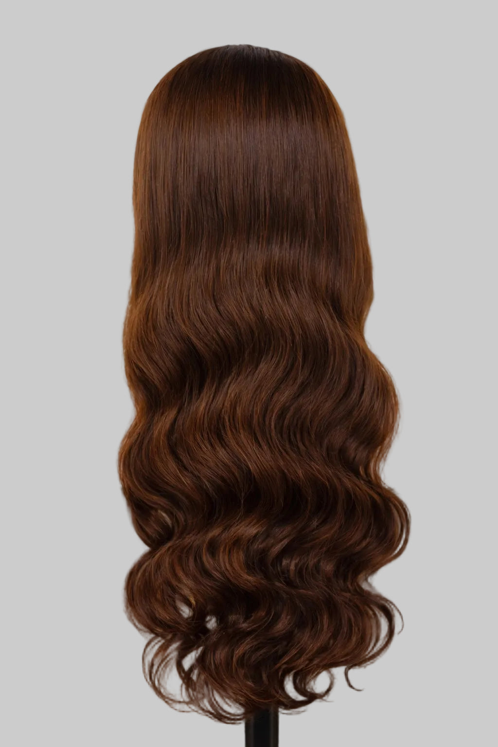 Person with long, wavy brown hair in a salon setting