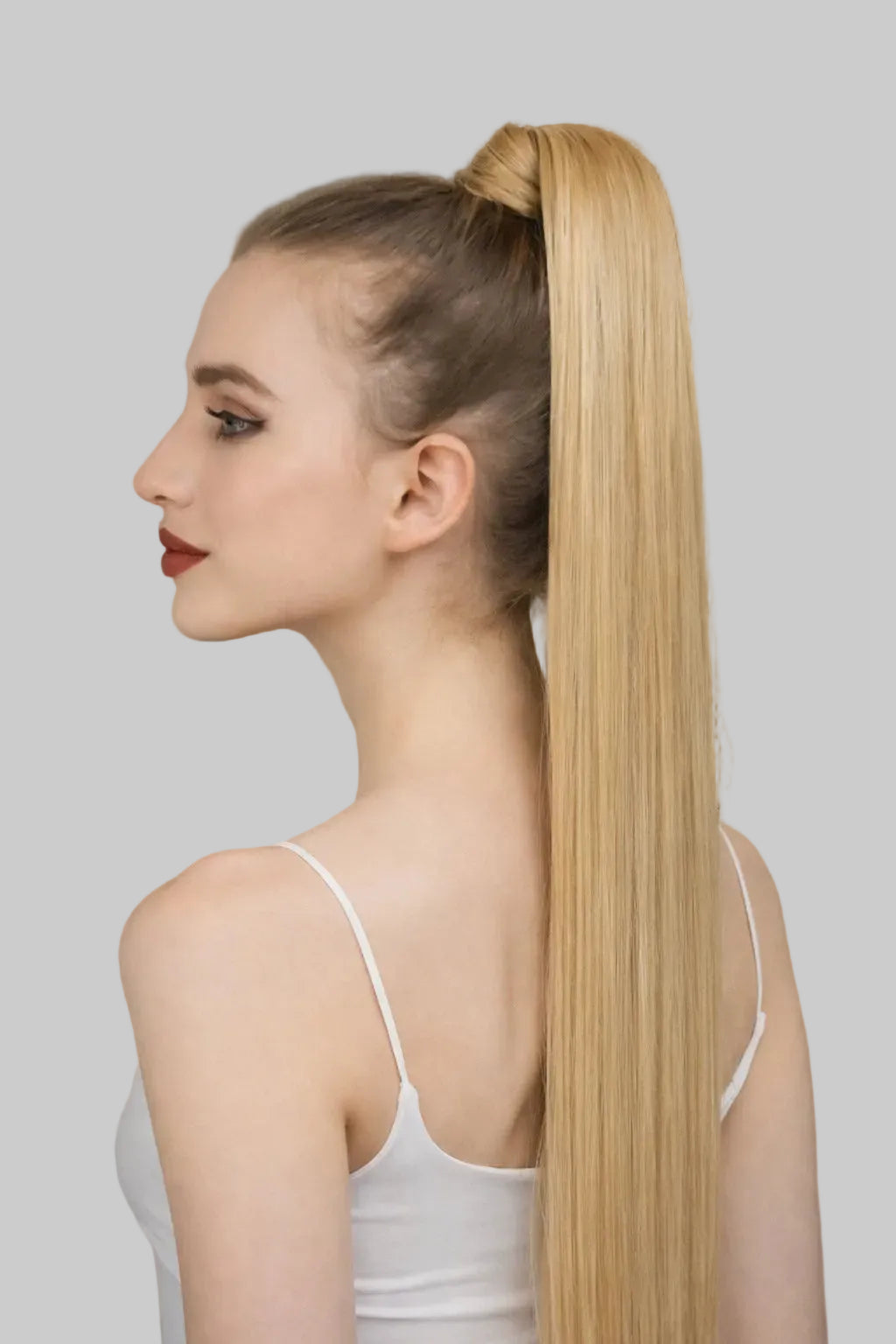 Woman with a long blonde ponytail in an indoor setting